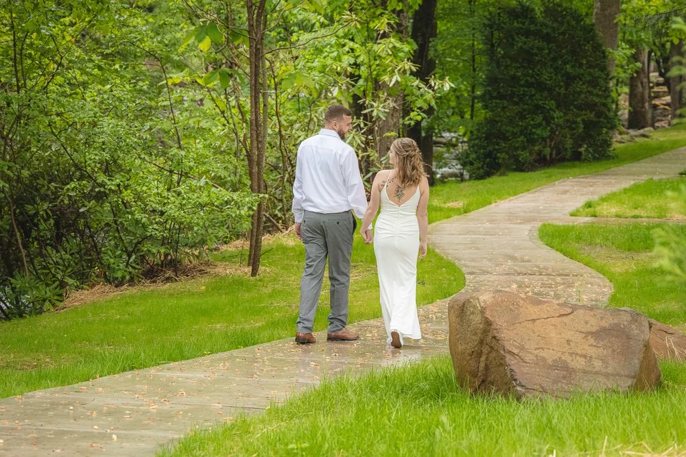 bride and groom walking by the creek