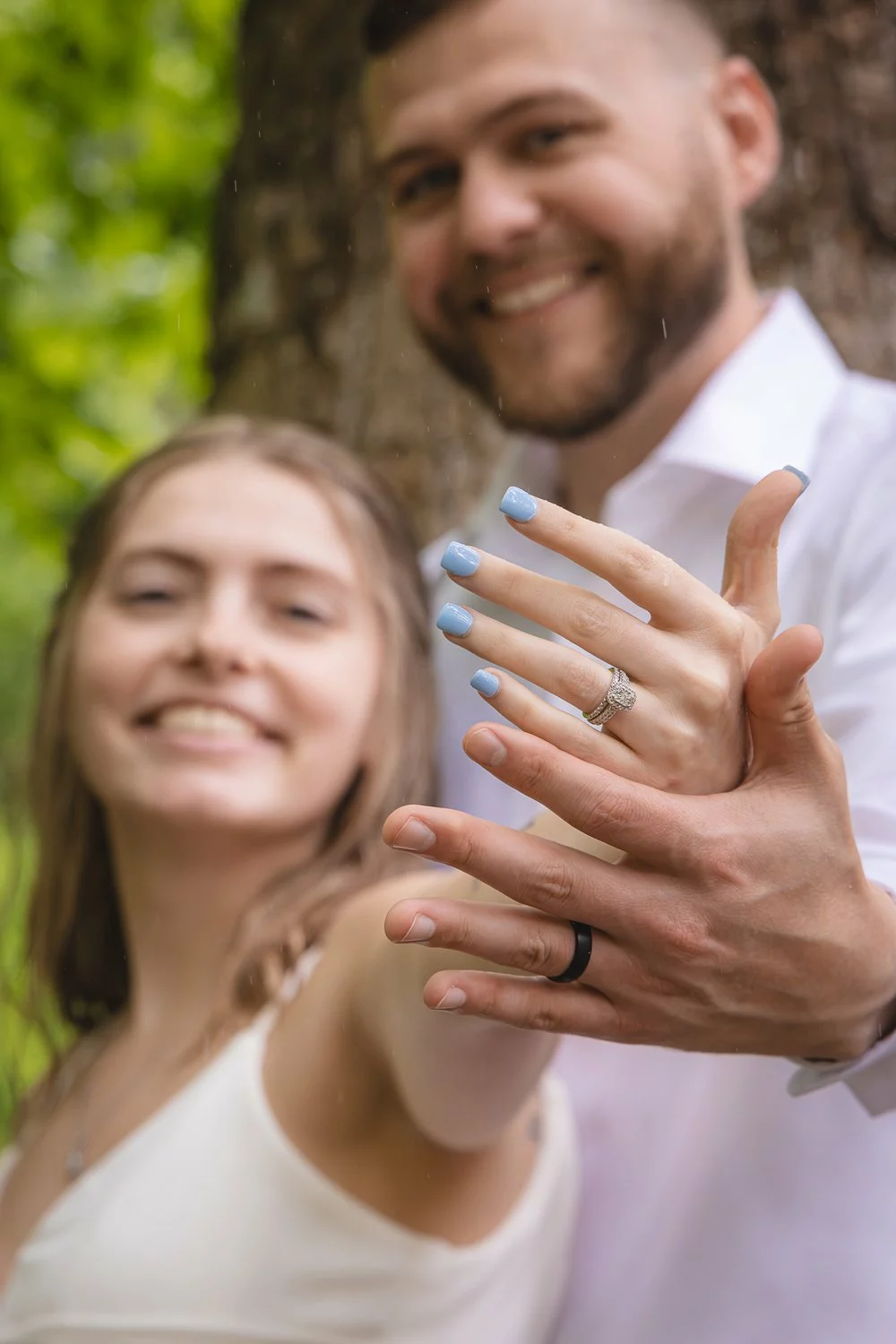 bride and groom showing off rings